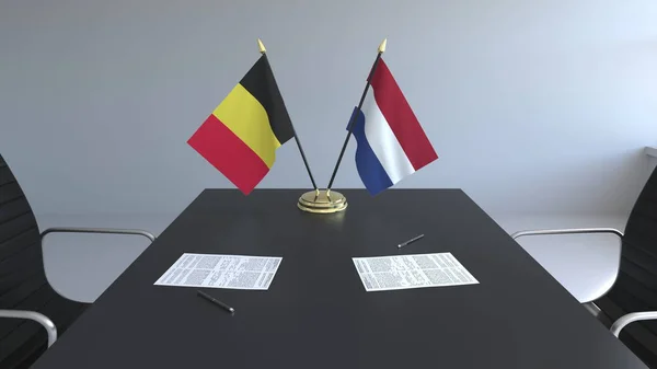 Σημαία του Βελγίου και Ολλανδίας και χαρτιά στο τραπέζι. Οι διαπραγματεύσεις και η υπογραφή μιας διεθνούς συμφωνίας. Εννοιολογική 3d rendering — Φωτογραφία Αρχείου