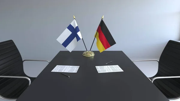Bandeiras da Finlândia e da Alemanha e papéis na mesa. Negociações e assinatura de um acordo internacional. Renderização 3D conceitual — Fotografia de Stock