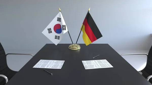 Bandeiras da Coreia do Sul e Alemanha e papéis na mesa. Negociações e assinatura de um acordo internacional. Renderização 3D conceitual — Fotografia de Stock