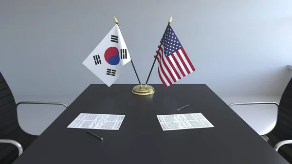 Lijst van vlaggen van Zuid-Korea en de Verenigde Staten en de papieren op tafel. Onderhandelingen en ondertekening van een internationale overeenkomst. Conceptuele 3D-rendering — Stockfoto