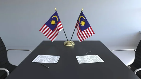 Flaggor av Malaysia och papper på bordet. Förhandlingarna och underteckna ett avtal. Konceptuell 3d-rendering — Stockfoto