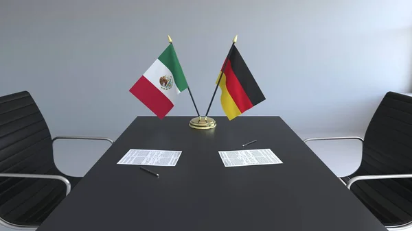 Banderas de México y Alemania y papeles sobre la mesa. Negociaciones y firma de un acuerdo internacional. Renderizado 3D conceptual —  Fotos de Stock