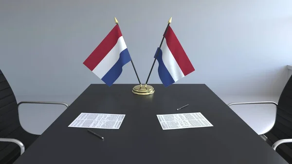 Banderas de los Países Bajos y documentos sobre la mesa. Negociaciones y firma de un acuerdo. Renderizado 3D conceptual —  Fotos de Stock