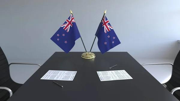 Flaggen von Neuseeland und Papiere auf dem Tisch. Verhandlungen und Unterzeichnung eines Abkommens. konzeptionelles 3D-Rendering — Stockfoto
