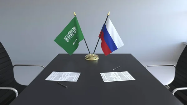 Bandeiras da Arábia Saudita e da Rússia e papéis na mesa. Negociações e assinatura de um acordo internacional. Renderização 3D conceitual — Fotografia de Stock
