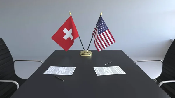 Flaggen der Schweiz und der Vereinigten Staaten und Papiere auf dem Tisch. Verhandlungen und die Unterzeichnung eines internationalen Abkommens. konzeptionelles 3D-Rendering — Stockfoto