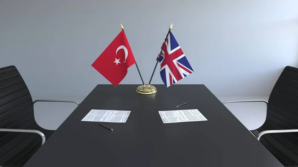 Bandiere della Turchia e del Regno Unito e documenti sul tavolo. Negoziati e firma di un accordo internazionale. Rendering 3D concettuale — Foto Stock