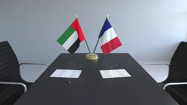 Флаги Объединенных Арабских Эмиратов и Франции и бумаги на столе. Переговоры и подписание международного соглашения. Концептуальная 3D рендеринг — стоковое фото