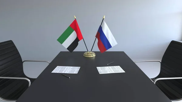 Drapeaux des Émirats arabes unis et de la Russie et papiers sur la table. Négociations et signature d'un accord international. rendu 3D conceptuel — Photo