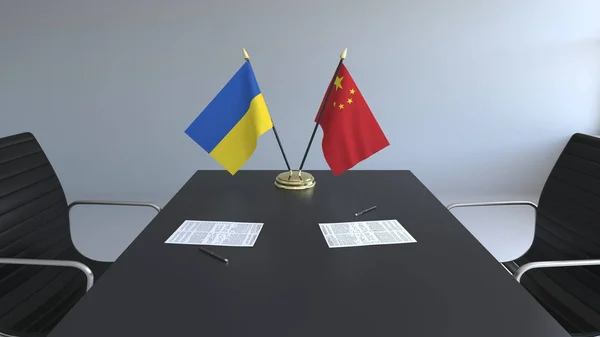Flaggen der Ukraine und Chinas und Papiere auf dem Tisch. Verhandlungen und die Unterzeichnung eines internationalen Abkommens. konzeptionelles 3D-Rendering — Stockfoto