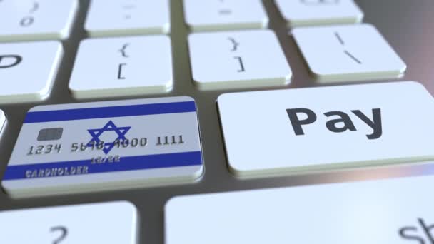 Tarjeta bancaria con la bandera de Israel como una tecla en un teclado de ordenador. Animación conceptual de pago en línea israelí — Vídeo de stock