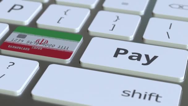 Bankkaart met vlag van Iran als een toets op het computertoetsenbord van een. Iraanse online betaling conceptuele animatie — Stockvideo