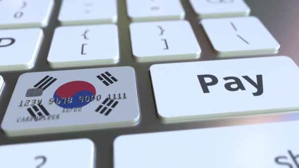 Банковская карта с флагом Южной Кореи в виде ключа на компьютерной клавиатуре. Концептуальная анимация онлайн-платежей — стоковое видео