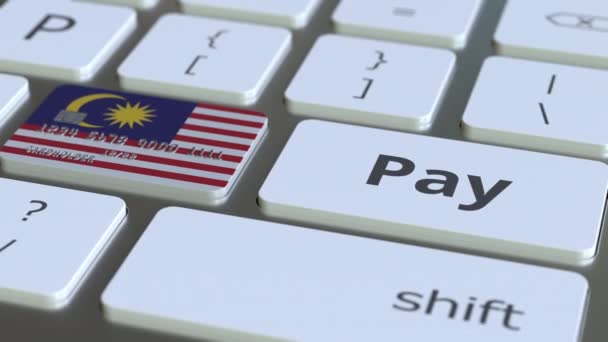 Tarjeta bancaria con la bandera de Malasia como una tecla en un teclado de computadora. Animación conceptual de pago en línea de Malasia — Vídeo de stock