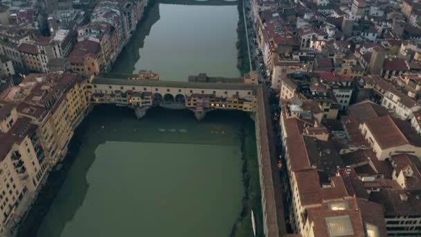 Foto aérea del famoso puente Ponte Vecchio y el río Arno por la noche. Florencia, Italia — Vídeo de stock