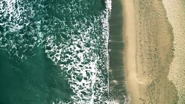 Vista aérea de arriba hacia abajo del mar surf en la playa con muchas huellas — Vídeo de stock