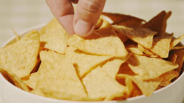 Muž vybere tortilla čip z desky, close-up shot — Stock fotografie