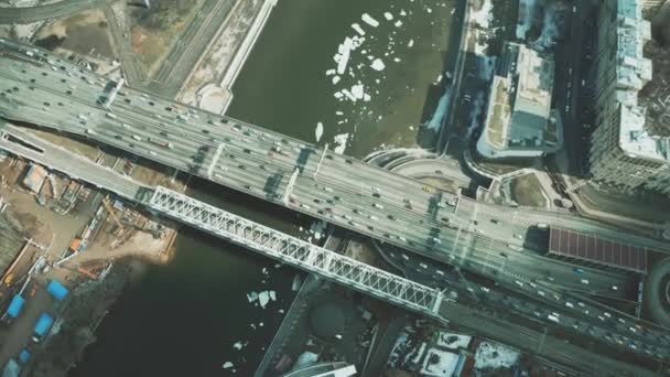 Εναέρια κάτω προβολή αυτοκίνητα κινούνται κατά μήκος της γέφυρας σε παγωμένο ποτάμι — Αρχείο Βίντεο