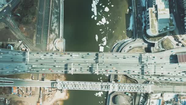 Vista aérea de arriba hacia abajo de los puentes de coches y ferrocarriles sobre el río helado — Vídeos de Stock