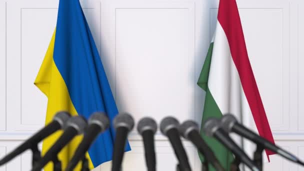Flaggen der Ukraine und Ungarns bei internationalen Treffen oder Verhandlungen Pressekonferenz. 3D-Animation — Stockvideo