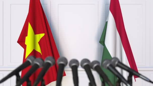 Флаги Вьетнама и Венгрии на международной встрече или пресс-конференции. 3D анимация — стоковое видео