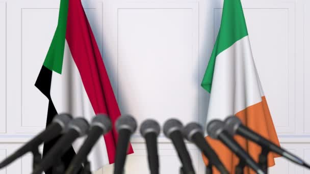 Flags of Sudan and Ireland at international meeting or negotiations press conference. 3D animation — Stock Video