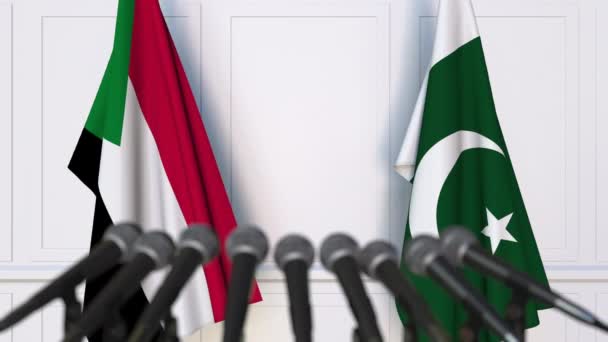 Флаги Судана и Пакистана на международной встрече или пресс-конференции. 3D анимация — стоковое видео