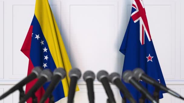 委内瑞拉和新西兰在国际会议或谈判新闻发布会上的旗帜。3d 动画 — 图库视频影像