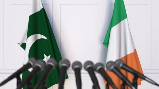 Флаги Пакистана и Ирландии на международной встрече или пресс-конференции переговоров. 3D анимация — стоковое видео