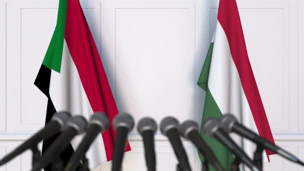 Flags of Sudan and Hungary at international meeting or negotiations press conference. 3D animation — Stock Video