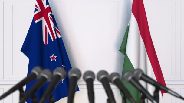 Banderas de Nueva Zelanda y Hungría en la reunión internacional o en la conferencia de prensa de negociaciones. Animación 3D — Vídeos de Stock
