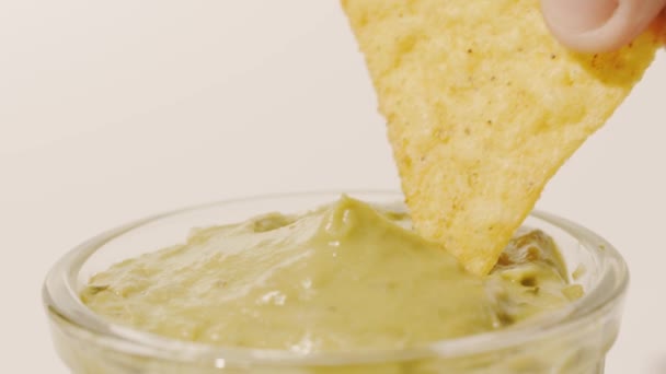 Окунание чипсов в соус гуакамоле — стоковое видео
