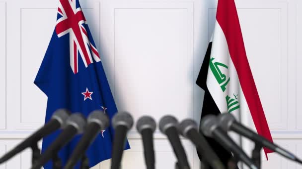 Bandiere della Nuova Zelanda e dell'Iraq alla riunione internazionale o alla conferenza stampa dei negoziati. Animazione 3D — Video Stock