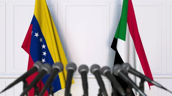 Flaggor av Venezuela och Sudan vid internationella förhandlingar eller möte presskonferens. 3D-rendering — Stockfoto