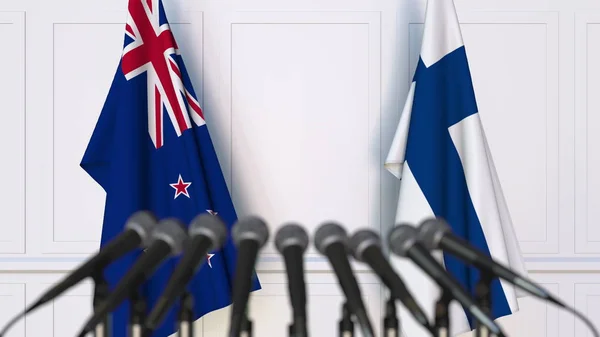 Flaggor i Nya Zeeland och Finland vid internationella förhandlingar eller möte presskonferens. 3D-rendering — Stockfoto