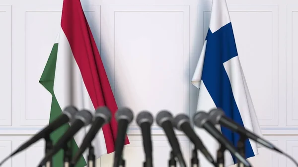 Flags of Hungary and Finland at international meeting or negotiations press conference. 3D rendering — Stock Photo, Image