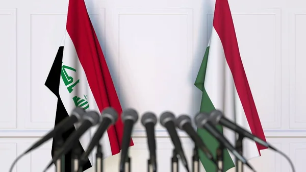国際会議や交渉の記者会見でイラク、ハンガリーの国旗。3 d レンダリング — ストック写真