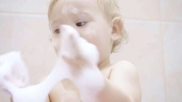 Happy baby speelt met schuim in de badkamer — Stockvideo