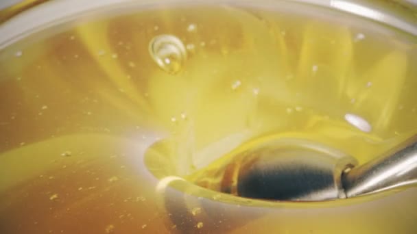 Tomando un poco de miel con un cazo de miel de metal, macro shot — Vídeo de stock