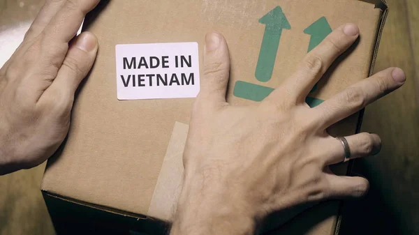 Colocación de pegatina con texto MADE IN VIETNAM en la caja —  Fotos de Stock