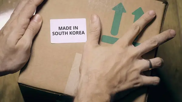 Umieszczenie naklejki z Made in Korea Południowa tekst na pudełku — Zdjęcie stockowe