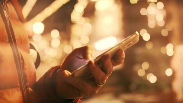 Man using his smartphone in the winter evening. Scrolling an app, close-up. Shot on Red camera — Stock Video