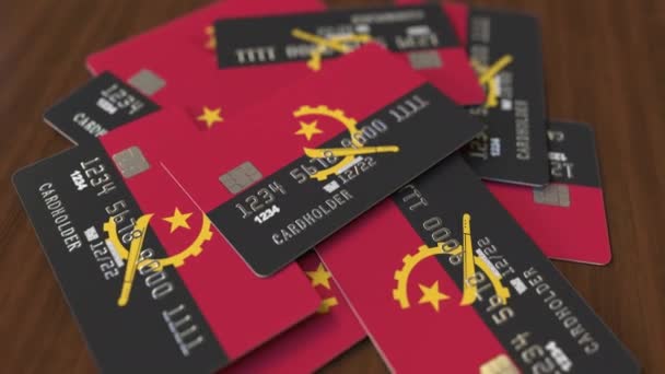 Montón de tarjetas de crédito con bandera de Angola. Sistema bancario angoleño animación 3D conceptual — Vídeo de stock