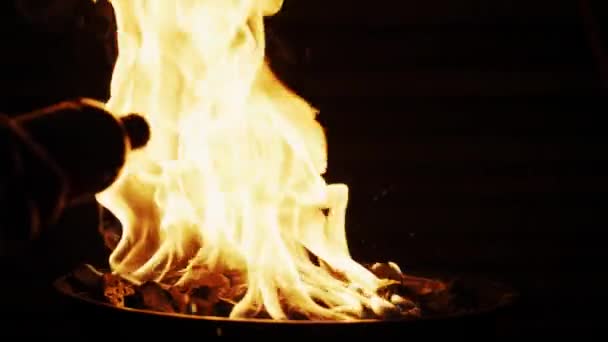 Pouring charcoal lighter fluid into barbecue grill fire. Slow motion shot on Red camera — Stock Video