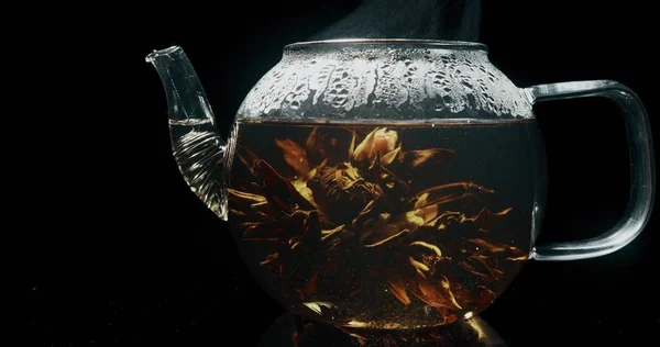 Hot blooming tea in a glass teapot