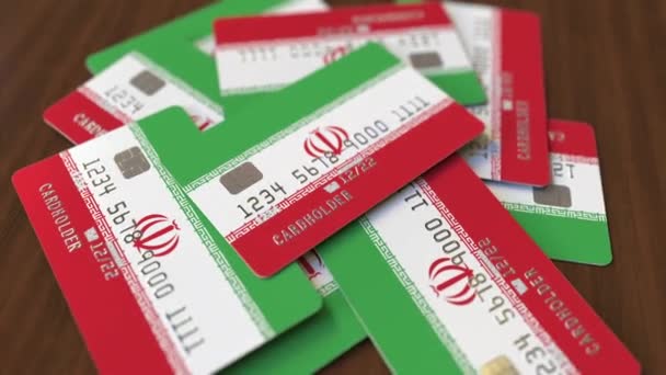 Montón de tarjetas de crédito con bandera de Irán. Sistema bancario iraní animación 3D conceptual — Vídeo de stock