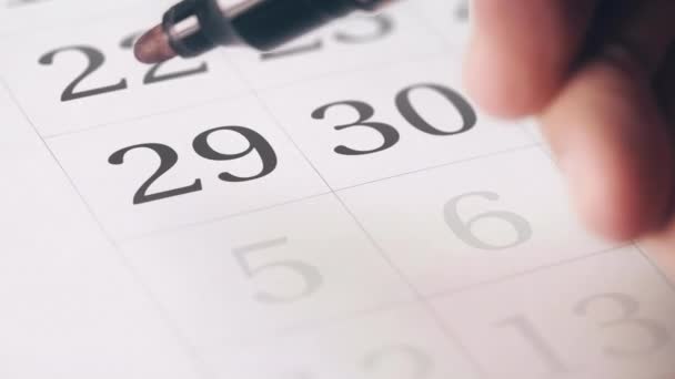 Het tekenen van een rode omcirkelde markering op de negenentwintig 29-dag van een maand in de kalender — Stockvideo