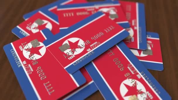 北朝鮮の国旗を持つクレジットカードの山。ナショナルバンキングシステム概念3Dアニメーション — ストック動画