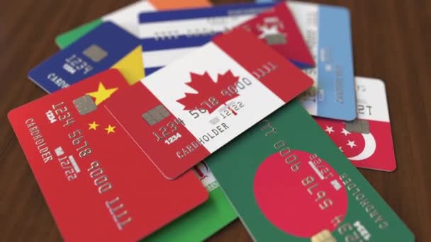 Muchas tarjetas de crédito con diferentes banderas, hizo hincapié en la tarjeta bancaria con bandera de Canadá — Vídeo de stock