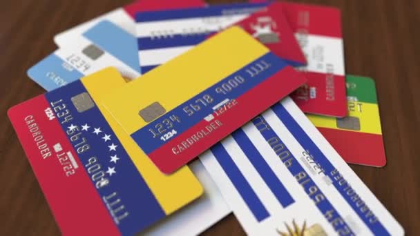 Viele Kreditkarten mit verschiedenen Flaggen, hervorgehobene Bankkarte mit kolumbianischer Flagge — Stockvideo